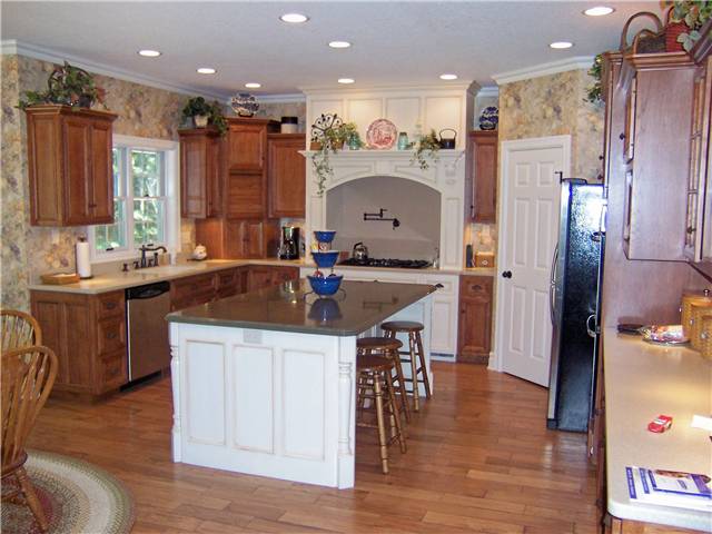Hickory cabinets - Painted island and cooking area - Flat panel miter corner doors, drawer fronts and side panels - Standard overlay style - Corian solid surface countertops